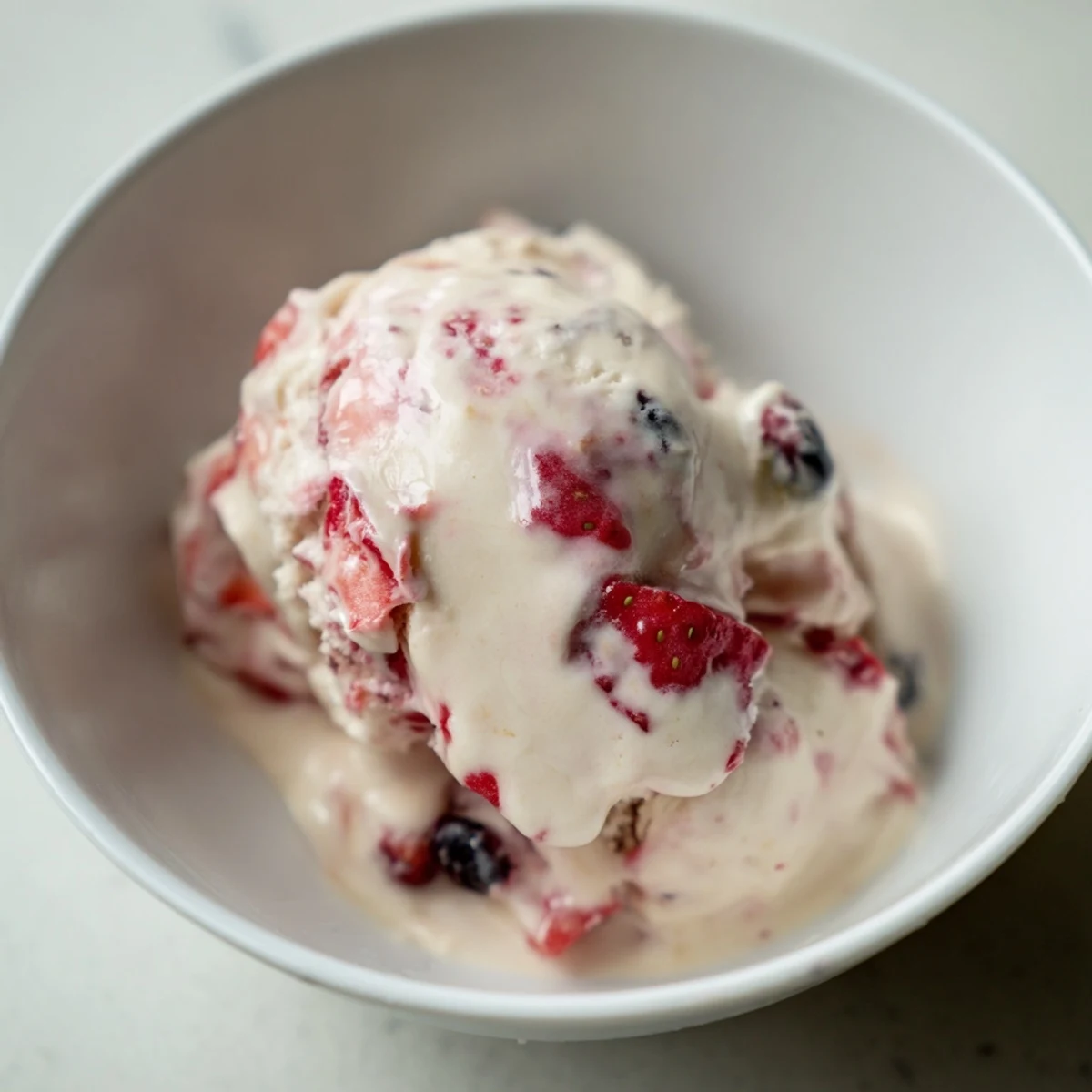 Smooth, sweet Cottage Cheese Ice Cream, showing a beautiful pink hue from blended berries.