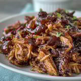 Savory pulled pork with honey and peach preserves, served hot and tender for a summer barbecue feast.  