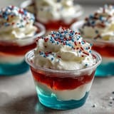 Colorful 4th of July Firecracker Jello Shots, layered red, white, and blue, ready for celebration.