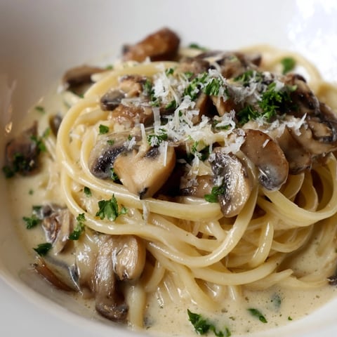 Golden sautéed mushrooms mingle with silky cream sauce draped over perfectly cooked creamy mushroom linguine, garnished with fresh parsley.