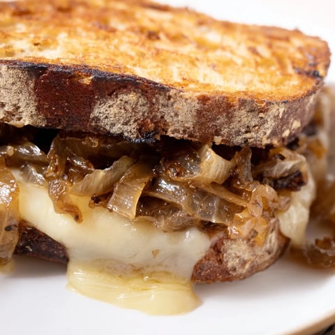 Golden-brown Caramelized Onion & Gruyère Grilled Cheese oozing with melted cheese and sweet onions.