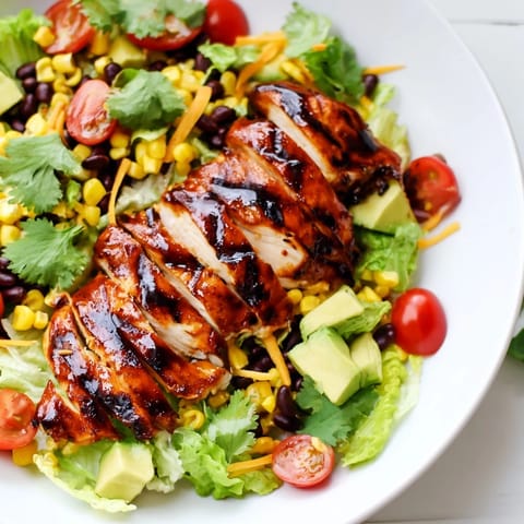 Honey Lime Chicken Taco Salad topped with juicy grilled chicken, shredded cheese, and crispy tortilla strips.  