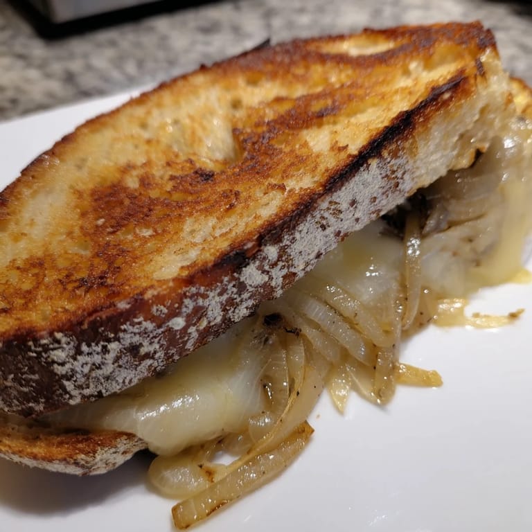Buttery slices of Caramelized Onion & Gruyère Grilled Cheese featuring crispy crusts and thick onions.