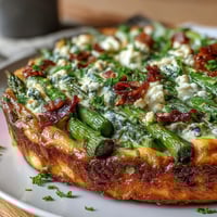 Spring Frittata with Asparagus, Peas and Goat Cheese: golden, herb-flecked egg dish baked with tender spring vegetables and creamy goat cheese crumbles.