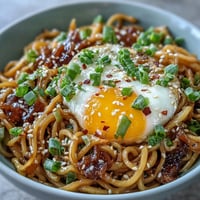 Glistening viral garlic butter ramen, ready with eggs and green onions.